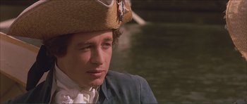 Movie still from “The Affair of the Necklace” (2001), directed by Charles Shyer – A young man wearing a straw hat near a body of water; Close Up shot, Over the shoulder angle