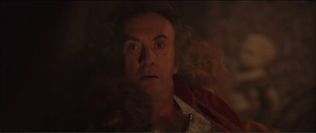 Movie still from “The Affair of the Necklace” (2001), directed by Charles Shyer – A man is laying in the dark looking at the camera; Close Up shot, Low angle