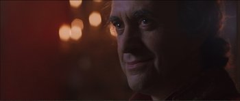 Movie still from “The Affair of the Necklace” (2001), directed by Charles Shyer – A man's face in front of lights; Close Up shot, Over the shoulder angle