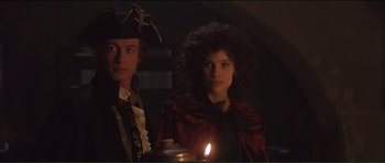 Movie still from “The Affair of the Necklace” (2001), directed by Charles Shyer – A man and a woman standing next to each other; Medium shot, Over the shoulder angle