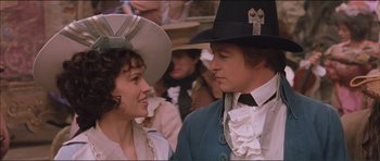 Movie still from “The Affair of the Necklace” (2001), directed by Charles Shyer – A man and a woman wearing hats in front of a crowd of onlookers; Medium shot, Over the shoulder angle
