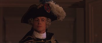 Movie still from “The Affair of the Necklace” (2001), directed by Charles Shyer – A man wearing a hat and a uniform; Close Up shot, Over the shoulder angle