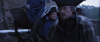 Movie still from “The Affair of the Necklace” (2001), directed by Charles Shyer – A man with a beard and a hat and a man with a beard and an umbrella; Medium shot, Low angle