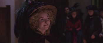 Movie still from “The Affair of the Necklace” (2001), directed by Charles Shyer – A woman in a hat is smiling for the camera; Close Up shot, Over the shoulder angle