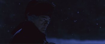 Movie still from “The Affair of the Necklace” (2001), directed by Charles Shyer – An old man wearing a red hat looking at the sky at night; Close Up shot, Over the shoulder angle