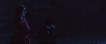 Movie still from “The Affair of the Necklace” (2001), directed by Charles Shyer – A person standing in the dark under a black umbrella; Wide shot, High angle