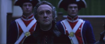 Movie still from “The Affair of the Necklace” (2001), directed by Charles Shyer – A person wearing a suit and hat; Close Up shot, Low angle