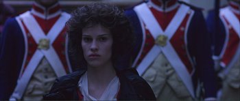 Movie still from “The Affair of the Necklace” (2001), directed by Charles Shyer – A young woman with curly brown hair wearing a black jacket; Close Up shot, Low angle