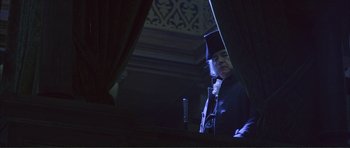 Movie still from “The Affair of the Necklace” (2001), directed by Charles Shyer – A man standing in front of a window at night; Medium shot, Low angle