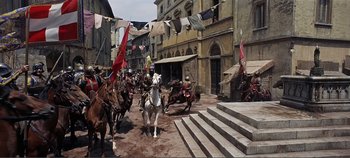 Movie still from “The Agony and the Ecstasy” (1965), directed by Carol Reed – A group of people riding horses down a street; Extreme Wide shot, High angle