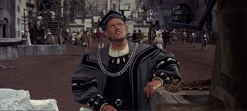 Movie still from “The Agony and the Ecstasy” (1965), directed by Carol Reed – A man in a black and gray outfit standing in front of a crowd of people; Medium shot, High angle
