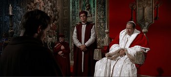 Movie still from “The Agony and the Ecstasy” (1965), directed by Carol Reed – A man standing in front of two other people; Wide shot, Over the shoulder angle