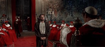 Movie still from “The Agony and the Ecstasy” (1965), directed by Carol Reed – A group of people sitting in a room with a man in a robe; Wide shot, Over the shoulder angle