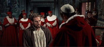 Movie still from “The Agony and the Ecstasy” (1965), directed by Carol Reed – Two men in medieval garb in front of a group of people; Medium shot, Over the shoulder angle