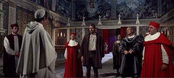Movie still from “The Agony and the Ecstasy” (1965), directed by Carol Reed – A group of people standing in a room with paintings on the walls; Wide shot, Over the shoulder angle