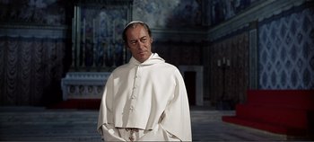 Movie still from “The Agony and the Ecstasy” (1965), directed by Carol Reed – A man wearing a white robe and a white hat; Medium shot, Low angle
