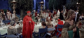 Movie still from “The Agony and the Ecstasy” (1965), directed by Carol Reed – A group of people sitting around a table with candles on it; Wide shot, Over the shoulder angle