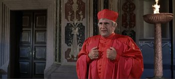 Movie still from “The Agony and the Ecstasy” (1965), directed by Carol Reed – A man in a red robe standing in front of a wall; Medium shot, High angle