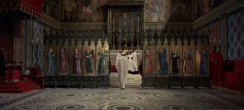 Movie still from “The Agony and the Ecstasy” (1965), directed by Carol Reed – A man in a white robe walking in front of a wall of paintings; Extreme Wide shot, Low angle