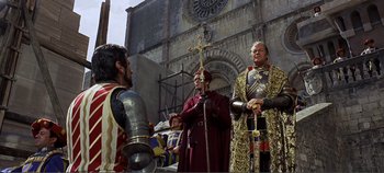 Movie still from “The Agony and the Ecstasy” (1965), directed by Carol Reed – A group of people standing next to each other in front of a building; Wide shot, Over the shoulder angle