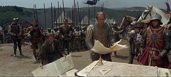 Movie still from “The Agony and the Ecstasy” (1965), directed by Carol Reed – A group of men in medieval garb standing around a table; Wide shot, High angle