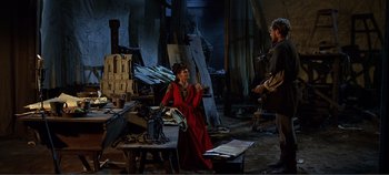 Movie still from “The Agony and the Ecstasy” (1965), directed by Carol Reed – A woman in a red dress is talking to a man in a black suit; Wide shot, High angle