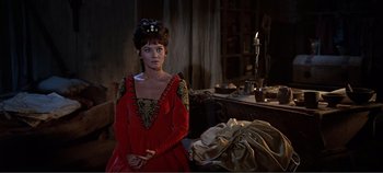 Movie still from “The Agony and the Ecstasy” (1965), directed by Carol Reed – A woman in a red dress sitting in a room; Medium shot, Over the shoulder angle