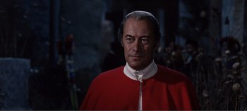Movie still from “The Agony and the Ecstasy” (1965), directed by Carol Reed – A man wearing a red robe and a white hat; Close Up shot, Over the shoulder angle