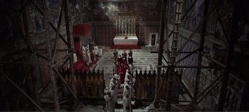 Movie still from “The Agony and the Ecstasy” (1965), directed by Carol Reed – A group of people in a room with a priest; Extreme Wide shot, High angle