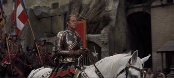 Movie still from “The Agony and the Ecstasy” (1965), directed by Carol Reed – A man dressed in a suit of armor and holding a sword on top of a white horse; Medium shot, Low angle