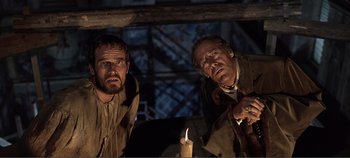 Movie still from “The Agony and the Ecstasy” (1965), directed by Carol Reed – A couple of men standing next to each other near a lit candle; Medium shot, Low angle