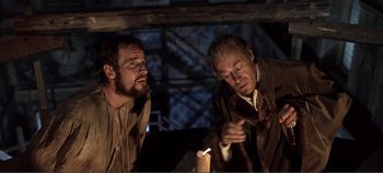 Movie still from “The Agony and the Ecstasy” (1965), directed by Carol Reed – Two men are looking at a candle in a dark room; Medium shot, Low angle