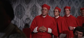 Movie still from “The Agony and the Ecstasy” (1965), directed by Carol Reed – A couple of men standing next to each other in red robes; Medium shot, Low angle