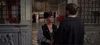 Movie still from “The Agony and the Ecstasy” (1965), directed by Carol Reed – A woman in a black and white outfit talking to a man in a black suit; Medium shot, Over the shoulder angle