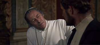 Movie still from “The Agony and the Ecstasy” (1965), directed by Carol Reed – A man wearing a white shirt and a chain around his neck; Close Up shot, Over the shoulder angle