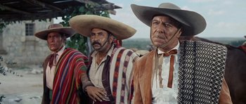 Movie still from “The Alamo” (1960), directed by John Wayne – Two mexican men in traditional clothing and hats; Medium shot, Low angle