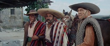 Movie still from “The Alamo” (1960), directed by John Wayne – A group of men standing next to each other on horses; Medium shot, Low angle