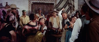 Movie still from “The Alamo” (1960), directed by John Wayne – A group of men and women in costumes and hats; Medium shot, Low angle