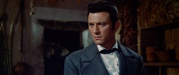 Movie still from “The Alamo” (1960), directed by John Wayne – A person wearing a suit and tie; Close Up shot, Low angle