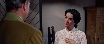Movie still from “The Alamo” (1960), directed by John Wayne – A woman is looking at herself in the mirror; Close Up shot, Over the shoulder angle