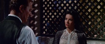 Movie still from “The Alamo” (1960), directed by John Wayne – A woman wearing a white shirt standing next to a man; Close Up shot, Over the shoulder angle