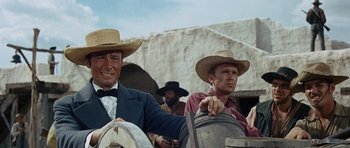 Movie still from “The Alamo” (1960), directed by John Wayne – Two men wearing hats and one is sitting on a horse; Close Up shot, Low angle