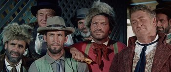 Movie still from “The Alamo” (1960), directed by John Wayne – A man with a beard is holding a piece of food; Close Up shot, Low angle