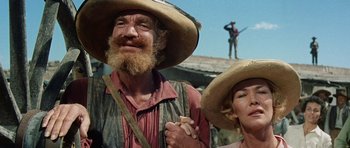 Movie still from “The Alamo” (1960), directed by John Wayne – A man and a woman wearing straw hats; Close Up shot, Low angle