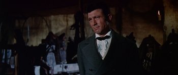 Movie still from “The Alamo” (1960), directed by John Wayne – A person wearing a suit and tie; Medium shot, Low angle