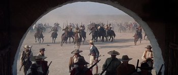 Movie still from “The Alamo” (1960), directed by John Wayne – A group of men on horseback in the middle of the desert; Extreme Wide shot, High angle