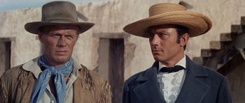 Movie still from “The Alamo” (1960), directed by John Wayne – Two men in hats and jackets standing next to each other; Close Up shot, Low angle