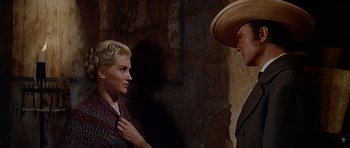 Movie still from “The Alamo” (1960), directed by John Wayne – A man and a woman standing next to each other; Medium shot, Over the shoulder angle