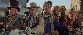 Movie still from “The Alamo” (1960), directed by John Wayne – A group of men standing next to each other in a field; Medium shot, Low angle