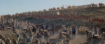 Movie still from “The Alamo” (1960), directed by John Wayne – A large group of men in uniforms standing next to each other on top of a hill; Extreme Wide shot, High angle